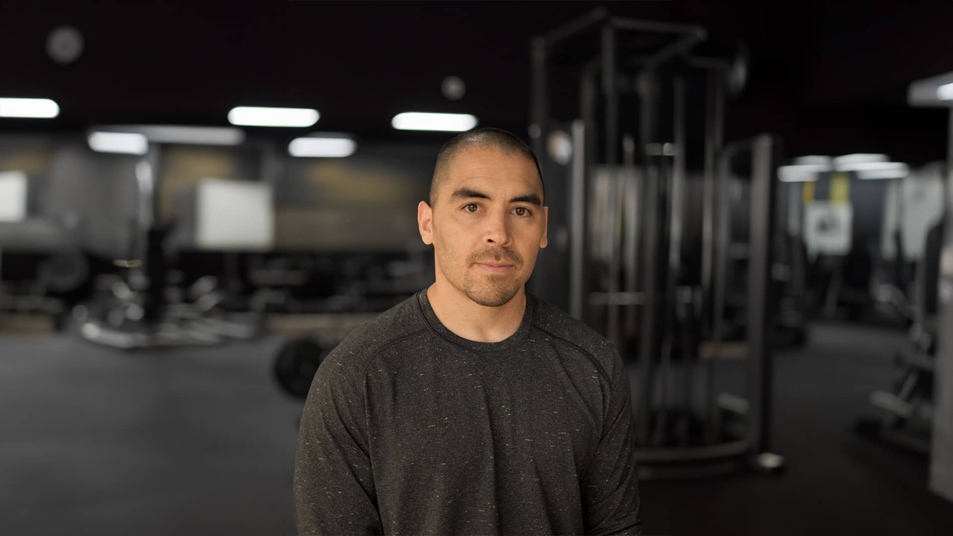 Photo of David Kawahata, PHD standing in a gym.